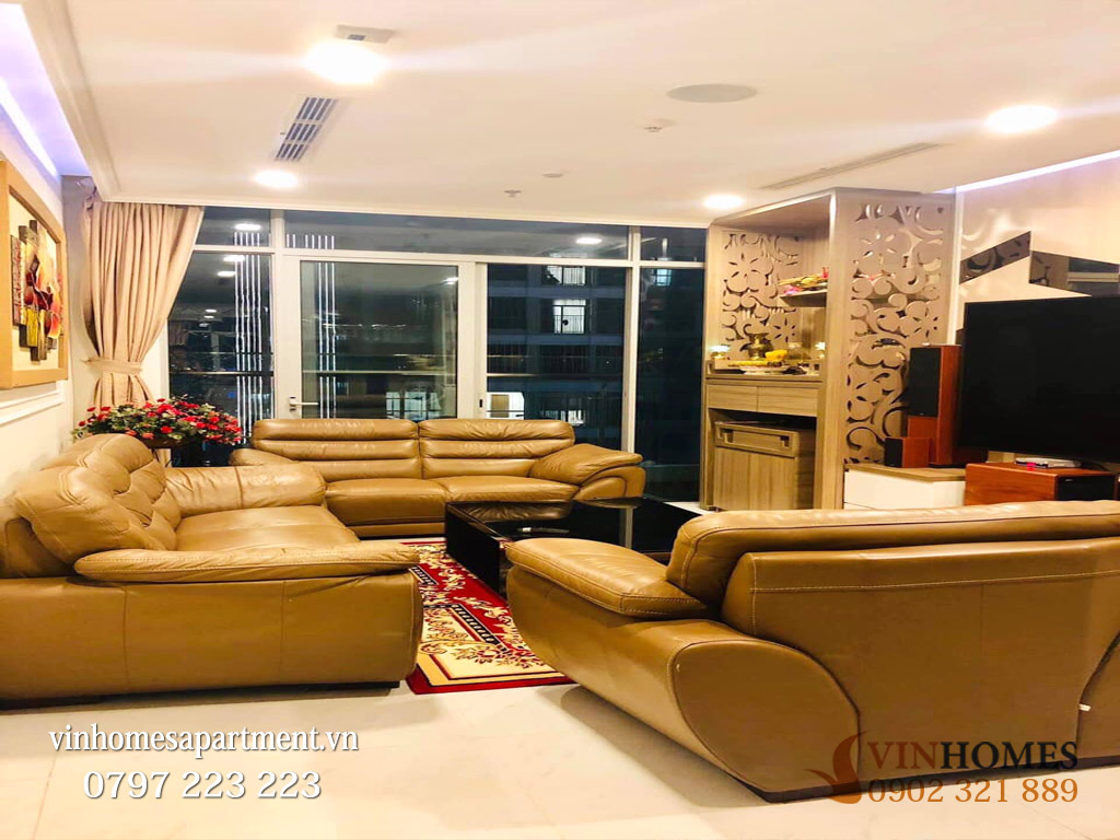 Ba hình ảnh thực tế bên trong căn hộ gồm phòng khách với sofa da, khu tiếp khách cạnh cửa kính và không gian bếp ăn thiết kế hiện đại, sang trọng.