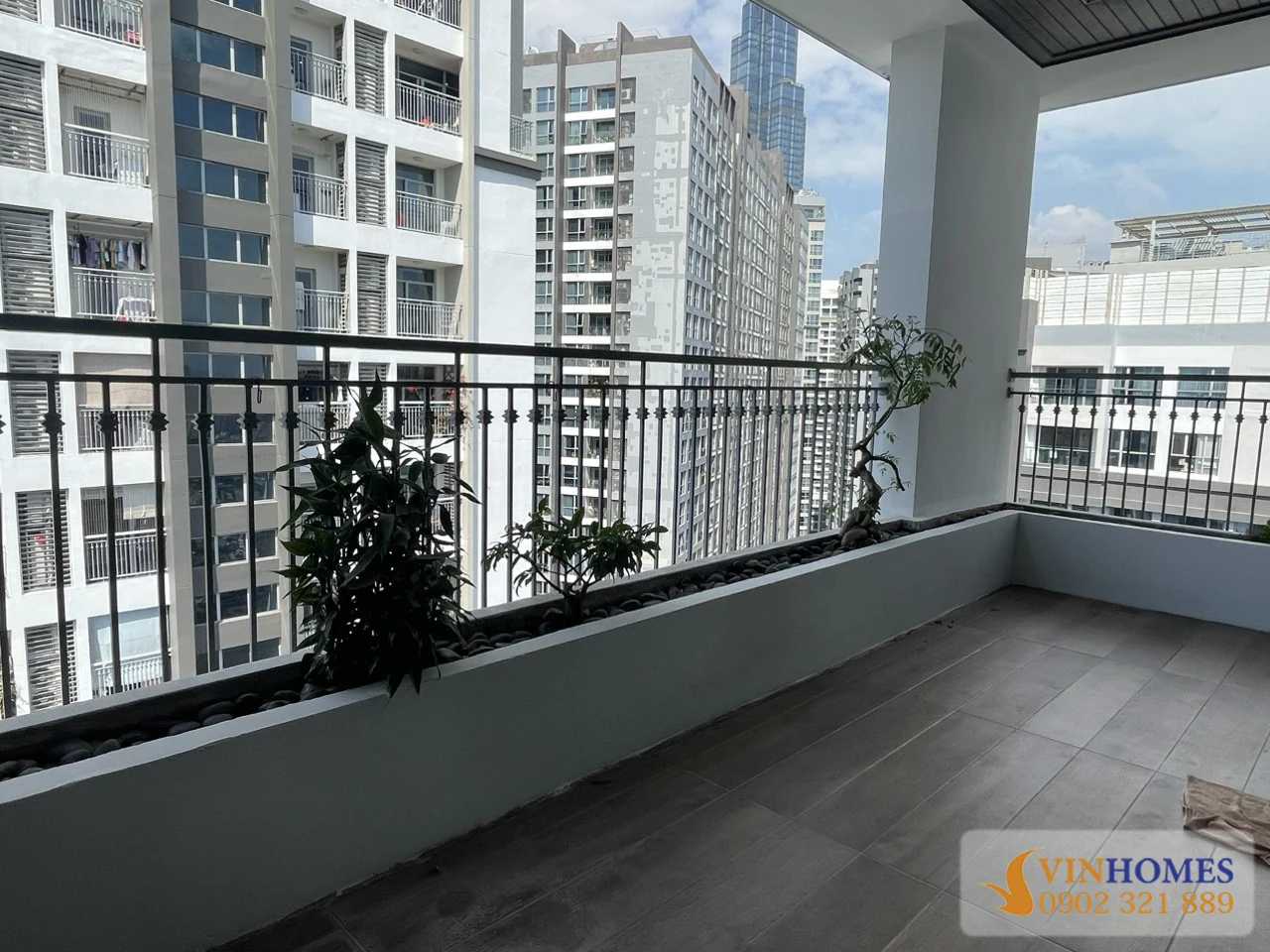 Ban công rộng của căn hộ Vinhomes Central Park với bồn cây dài và tầm nhìn thoáng ra các tòa nhà xung quanh