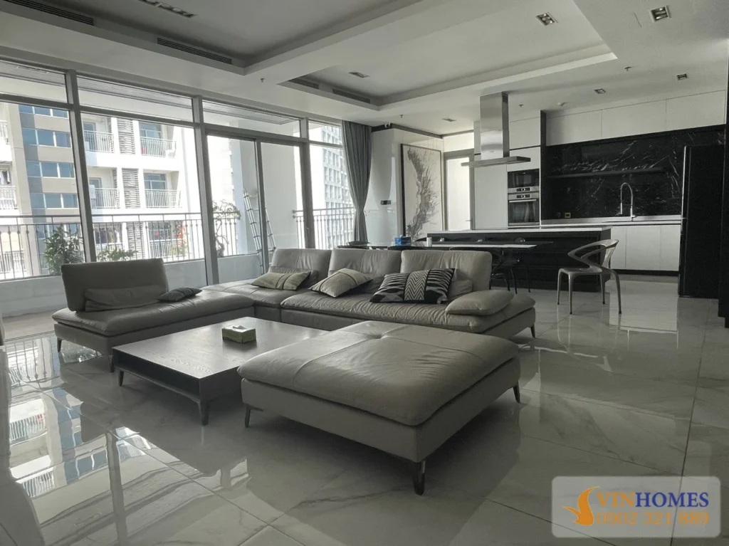 Phòng khách rộng căn hộ Vinhomes Central Park với sofa lớn, sàn đá bóng và khu bếp mở hiện đại