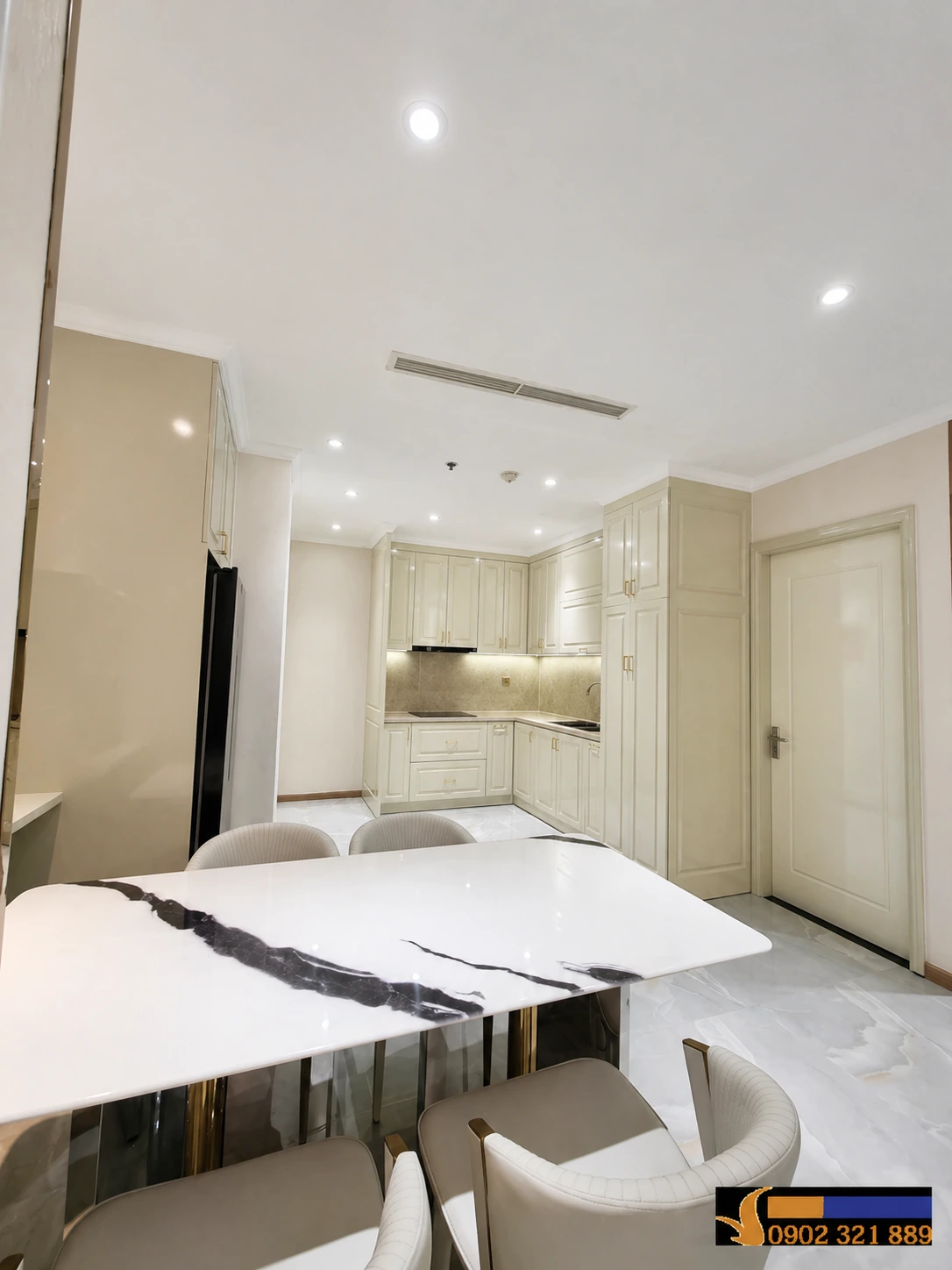 Phòng bếp và khu vực bàn ăn trong căn hộ 2 phòng ngủ Vinhomes Central Park cho thuê, thiết kế hiện đại, tông màu kem sang trọng.