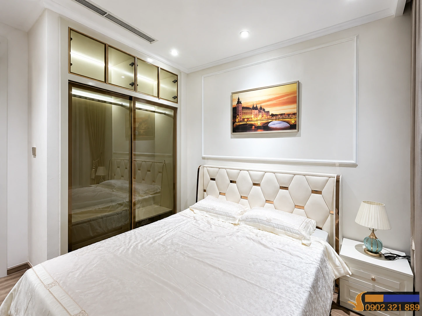 Phòng ngủ 1 trong căn hộ 2 phòng ngủ Vinhomes Central Park cho thuê với giường lớn, tủ quần áo kính và đèn ngủ.