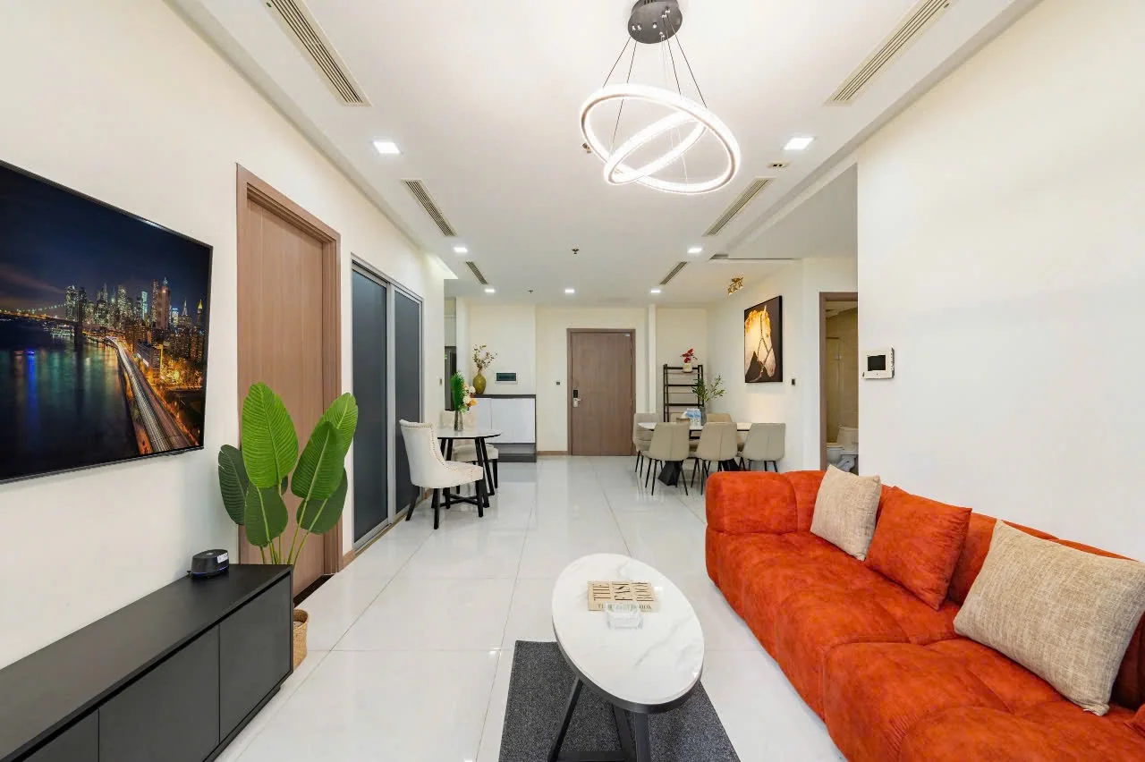 Phòng khách căn hộ Park 4 Vinhomes Central Park với sofa cam và cửa kính lớn đón ánh sáng